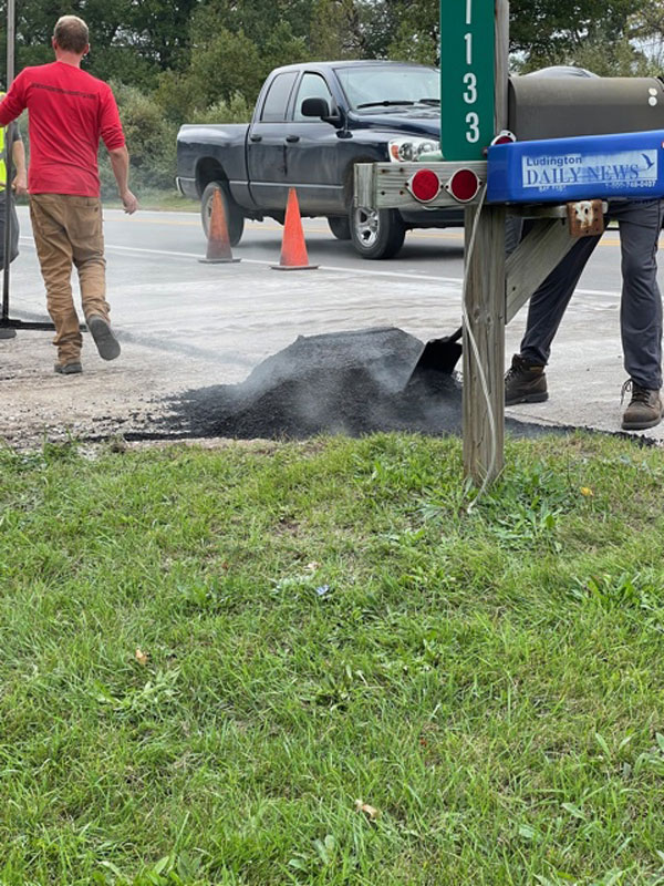 Black top being spread at driveway apron